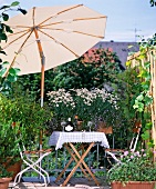 Blooming balcony with shady seating below parasol
