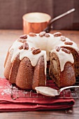 A banana wreath cake with icing and pecan nuts