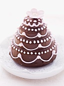 A mini wedding cake with chocolate glaze