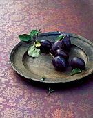 Plums on an old metal plate