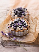 Two blueberry tartlets with lavender flowers