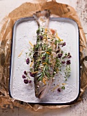 Char with various herbs on a bed of salt