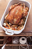 Roast chicken with root vegetables in a roasting tin