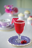 A raspberry daiquiri in a glass with a sugared edge