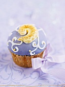 A cupcake decorated with purple icing
