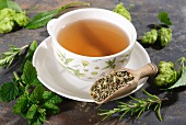 A cup of herbal tea surrounded by ingredients