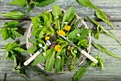 Various herbs in a basket with cutlery