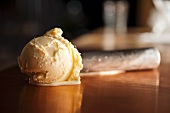 A Scoop of Vanilla Ice Cream Melting on a Table; Ice Cream Scooper