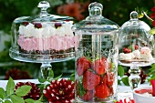 Cakes, strawberries, tartlets and dahlias on a summery table