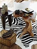 Small carved wooden table with African ornaments on zebra skin rug