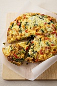 Vegetable Spanish Tortilla with Slice Removed; On a Cutting Board