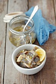 Preserved herrings in oil with lemons, garlic and marjoram