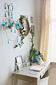 Small console table with drawers below sconce and framed portrait