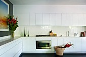 White, modern fitted kitchen with counter running along two walls