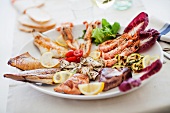 A plate of grilled food including seafood, fish and vegetables