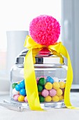 Jar of sweets decorated with yellow satin ribbon & pink pompom