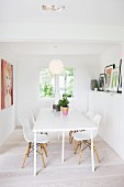 Modern, white kitchen table and Bauhaus-era shell chairs in dining room