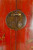 Metallschild mit Riegel auf rotem Holzschrank in asiatischem Stil