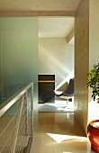Hallway with modern metal stair railing and looking through an open doorway on swivel chair