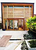 Contemporary home with wall of windows and wooden shutters for privacy