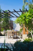 Table with chairs on a sunny terrace with sandstone pavers