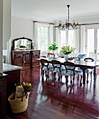 Reddish, shimmering precious wood takes command of this open kitchen-living room with traditional, antique style furniture