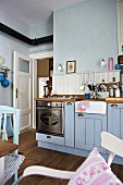 Gas cooker and ceramic sink in blue country-house kitchen