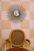 Rococo chair with mesh on back of wall decorations on wallpapered wall with white yellow plaid