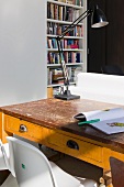 White Panton chairs at old school desk with open drawing book and old desk lamp