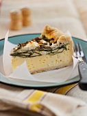 A Slice of Spinach and Goat Cheese Quiche on a Blue Plate