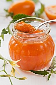 Yellow tomato jam in a jar and on a spoon