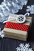 Weihnachtliche Geschenkschachtel mit Knopf und Bändern verziert
