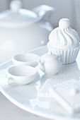 A mini teaset and cupcake made of porcelain