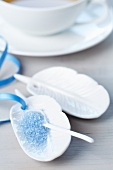 Small, feather-shaped plates with blue sugar