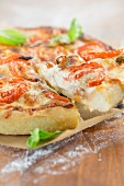 Deep Dish Pizza mit Basilikumblättern (Pizza mit hohem Rand, Chicago, USA), ein Stück auf Pizzaheber
