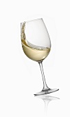 A tilting glass of white wine