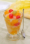 Fruit cocktail in a sundae glass with syrup-preserved fruit