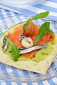 Knäckebrot belegt mit Guacamole, Lachs, Anchovis & Meeresfrüchten