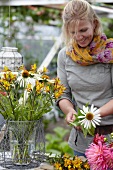 Frau arrangiert sommerlichen Blumenstrauss