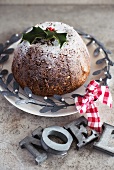 Christmas pudding with icing sugar and holly