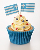 A cupcake decorated with buttercream and Greek flags