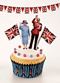 A cupcake topped with Queen Elizabeth II of England and the Duke of Edinburgh