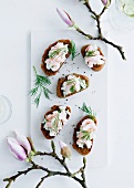 Slices of bread topped with prawns and dill
