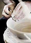 A potter creating a clay bowl on a potter's wheel