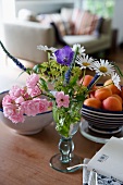 Summer posy in glass vase and fruit bowl on table