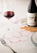 The Olympic rings marked in red wine on a white tablecloth
