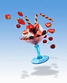 A flying strawberry sundae with flying ingredients
