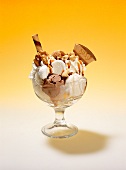 A nut sundae with vanilla and nut ice creams, cream, amarettini biscuits, wafers, nuts, meringues and butterscotch sauce
