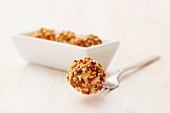 Tangy cream cheese balls on a fork and in a small oblong dish