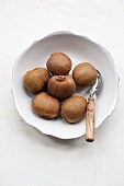 Kiwis in a bowl with a peeler